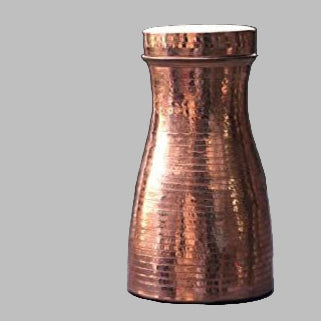 Copper shaker on a dark surface with a blurred background